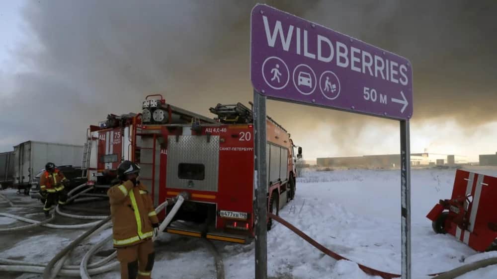 Firefighters stand at the scene of a burning warehouse of the Russian online retailer Wildberries in Shushary, outside St. Petersburg, Russia, 13 January 2024. Photo: EPA-EFE/ANATOLY MALTSEV