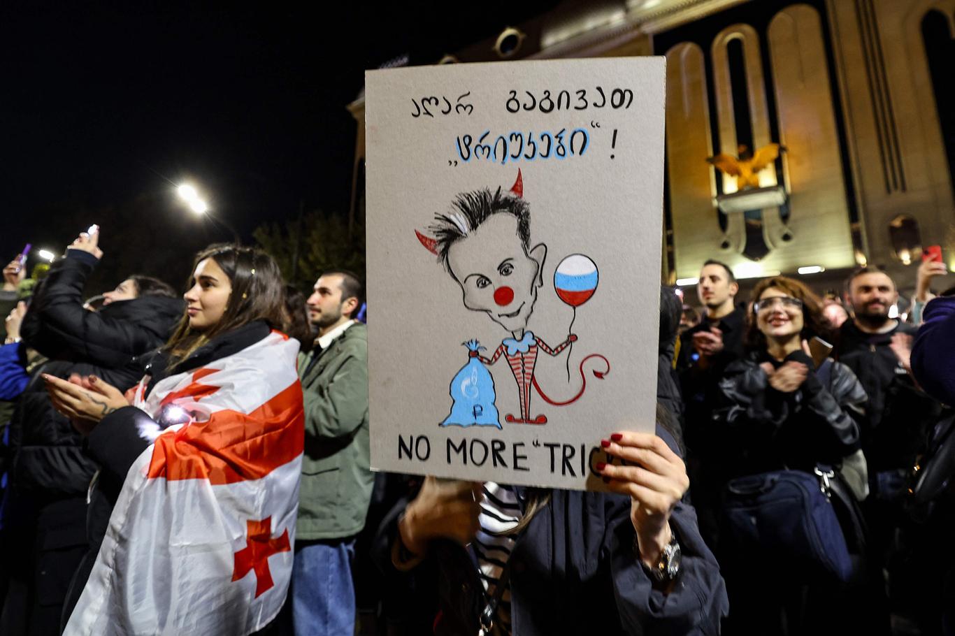 Участник акции протеста держит плакат с изображением грузинского олигарха и основателя правящей партии «Грузинская мечта» Бидзины Иванишвили. Тбилиси, Грузия. 28 октября 2024 года. Фото: Giorgi Arjevanidze / AFP / Scanpix / LETA