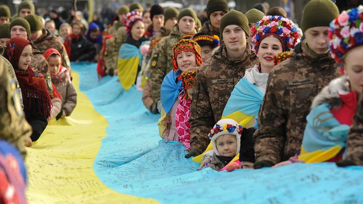 Locals carry a giant national flag signed by some 1,447 Ukrainian troops through the western Ukrainian city of Lviv, January 2024. Photo: EPA-EFE/MYKOLA TYS