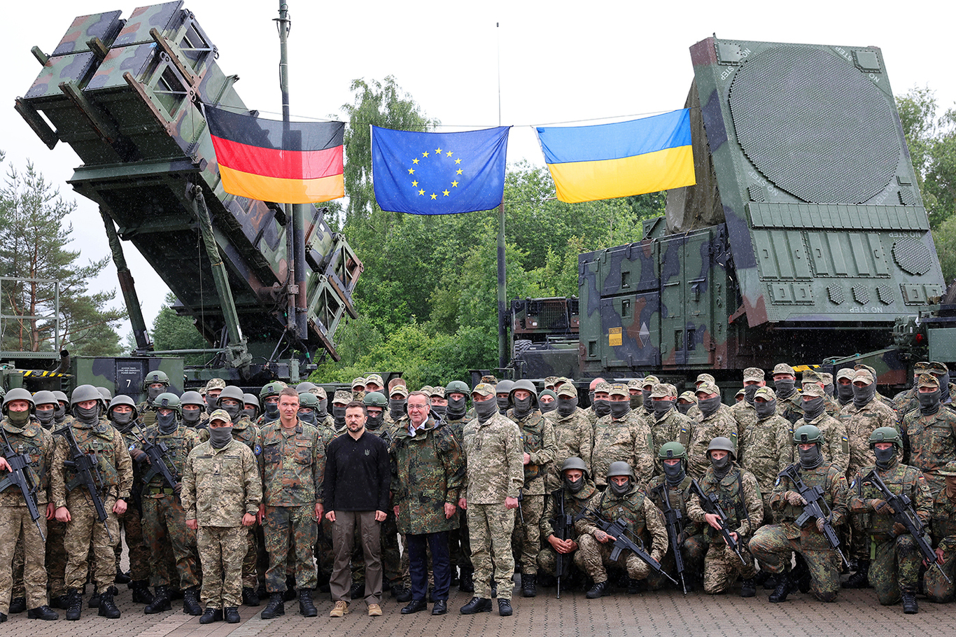 Президент Украины Владимир Зеленский и министр обороны Германии Борис Писториус с немецкими и украинскими солдатами перед зенитно-ракетными комплексами Patriot во время визита на военный полигон в Германии, 11 июня 2024 года. Фото: Jens Buettner / EPA