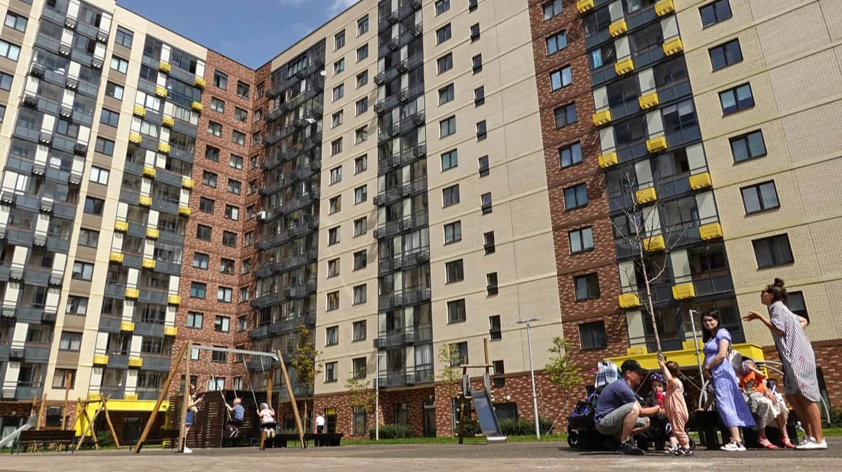 Жители стоят у новых жилых домов в Москве. Фото: Максим Шипенков / EPA
