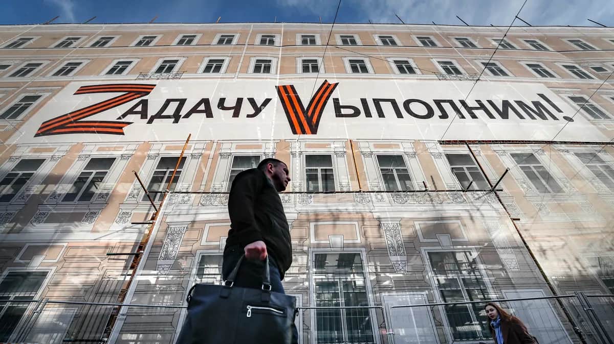 A man walks under an awning reading “We'll do our duty” in Moscow, 27 October 2022. Photo: EPA-EFE / YURI KOCHETKOV