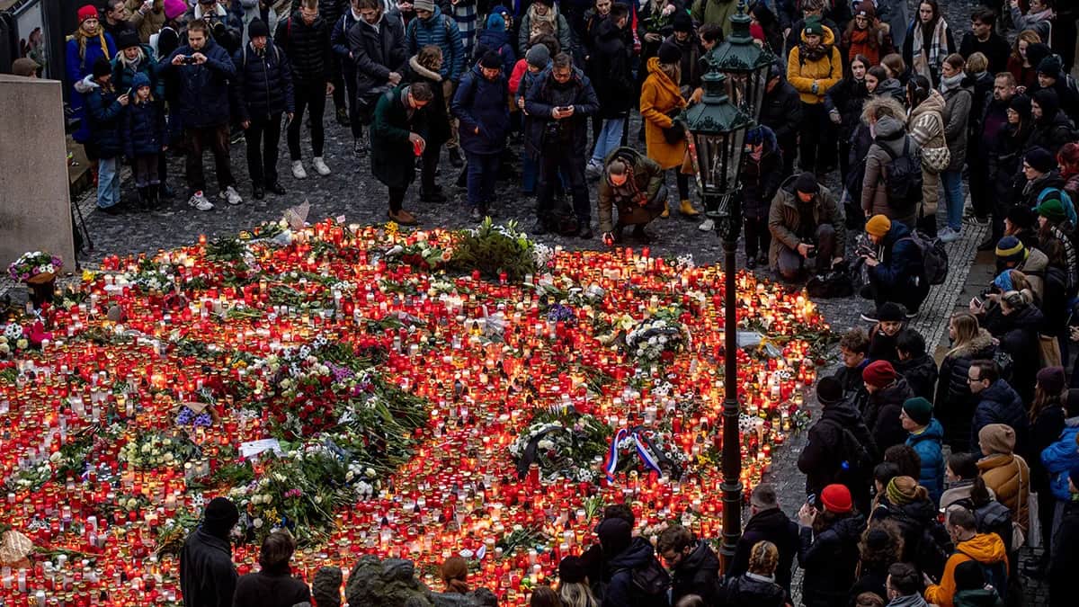 Люди возлагают цветы перед главным зданием Карлова университета после массовой стрельбы в здании философского факультета в центре Праги, 22 декабря 2023 года. Фото: Martin Divisek / EPA-EFE