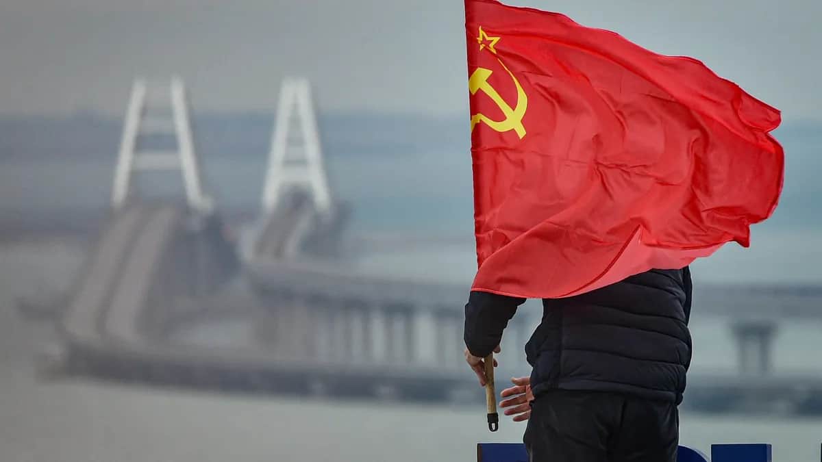 A man mounts a Soviet flag on an observation deck overlooking the Crimean Bridge on the anniversary of Russia’s annexation of Crimea. Photo: EPA-EFE / STRINGER