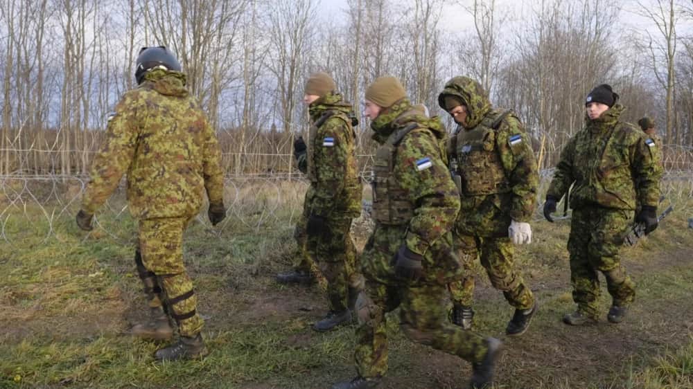 Estonian Defense Forces (EDF) reservists walk along a barbed wire barrier at the Estonian and Russian border during snap military exercise in Meremae, Estonia, 20 November 2021. Photo: EPA-EFE/VALDA KALNINA