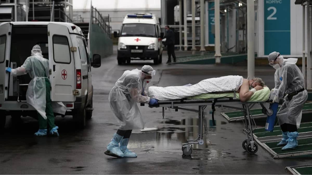 Медики сопровождают пациента с COVID-19 на территории больничного комплекса в Коммунарке. Москва, 5 ноября 2021 года. Фото: Максим Шипенков / EPA