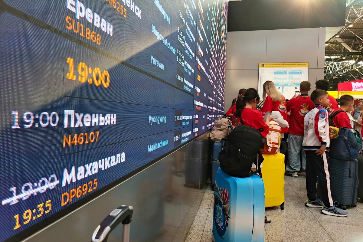 Пассажиры у табло, показывающим время вылета самолёта в Пхеньян в московском аэропорту Шереметьево, 27 июля 2025 года. Фото: AP Photo / Scanpix / LETA