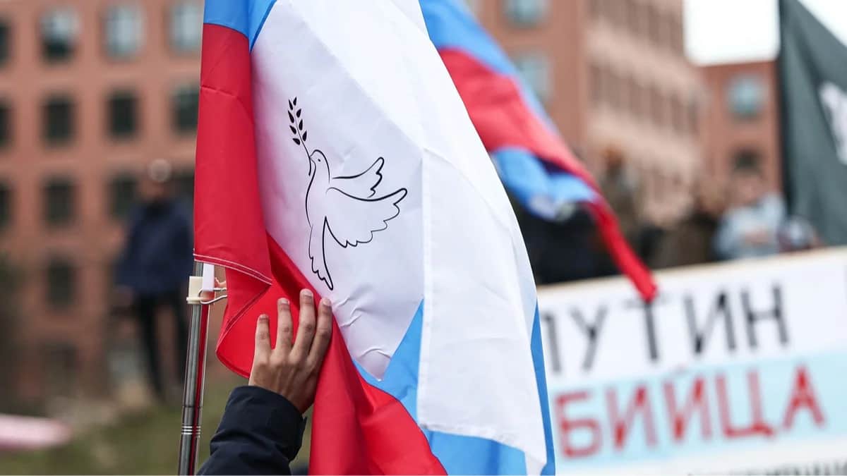 Участник акции держит российский флаг с голубем мира во время демонстрации в Берлине, Германия, 1 марта 2025 года. Фото: Hannes P. Albert / dpa / Scanpix / LETA