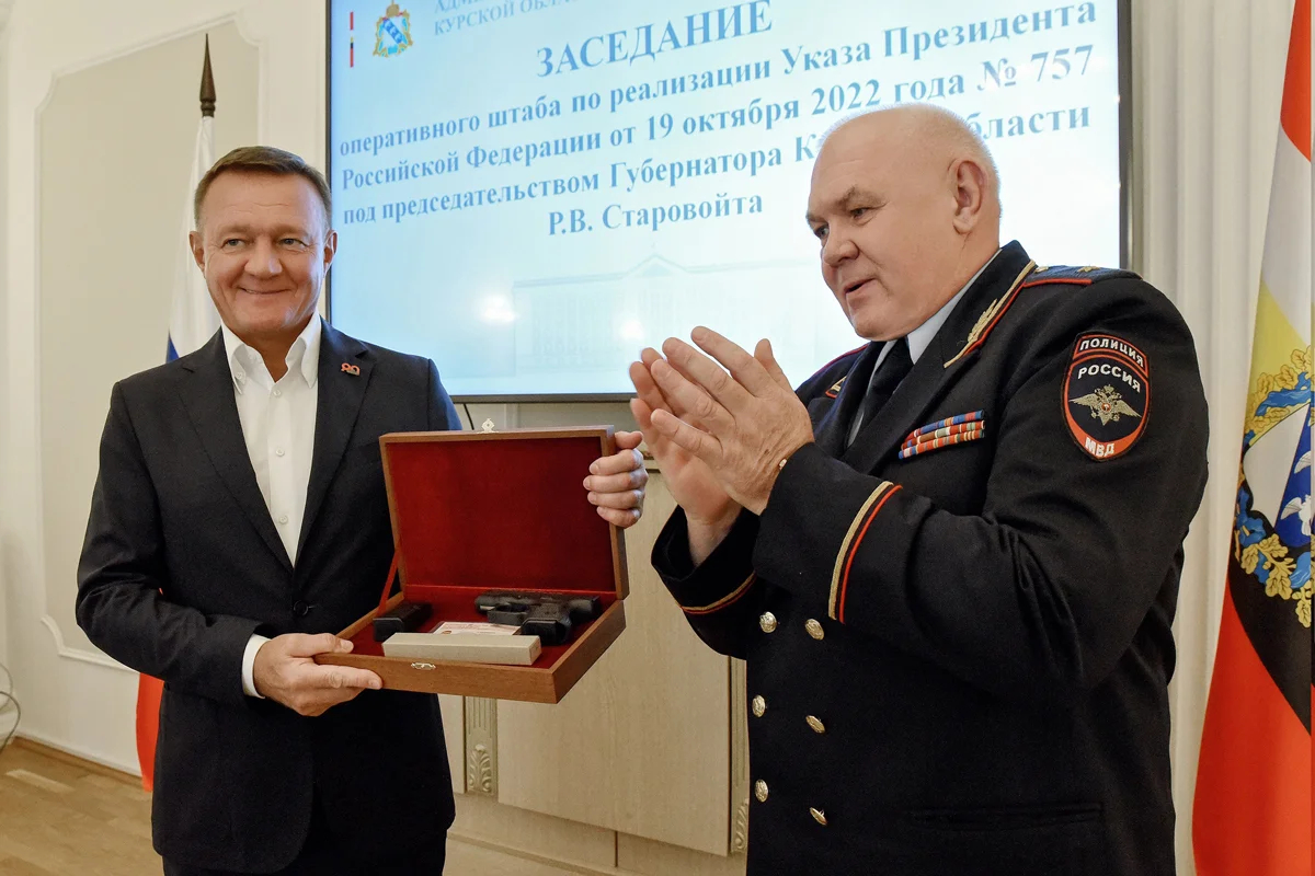 Начальник Управления МВД России по Курской области Виктор Косарев вручает Роману Старовойту наградное оружие, 18 октября 2023 года. Фото: пресс-служба Губернатора Курской области / VK