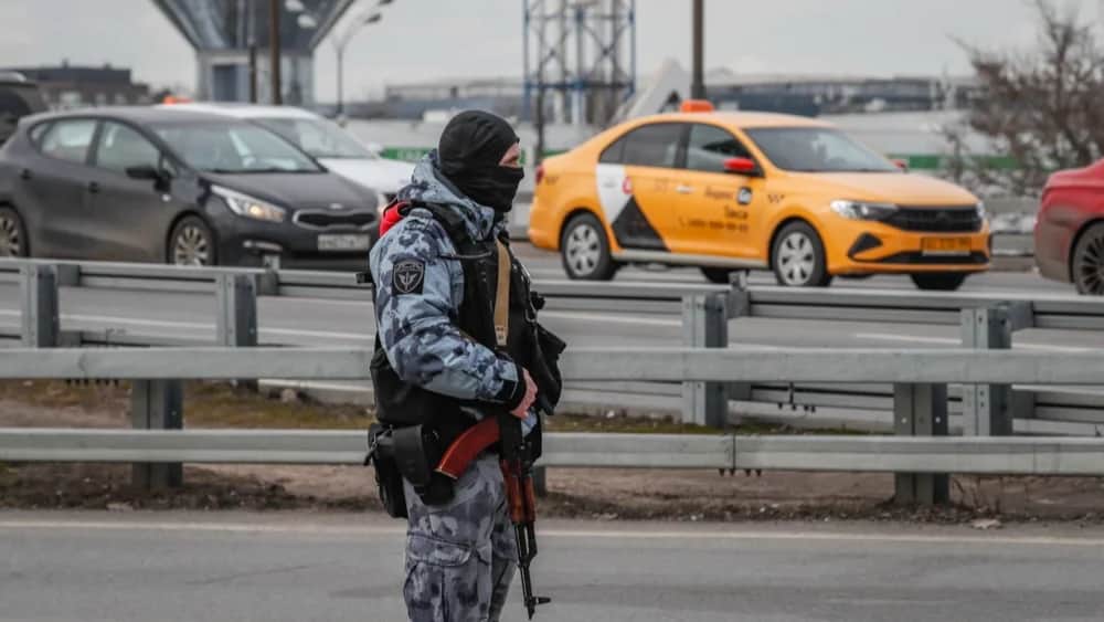 A police officer patrols in front of the burnt Crocus City Hall concert venue on 26 March. Photo: EPA-EFE/YURI KOCHETKOV