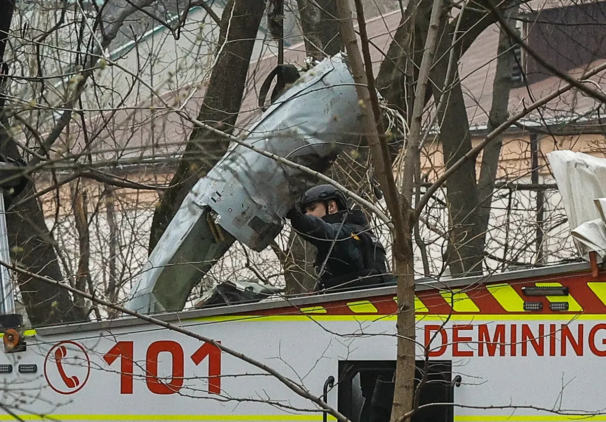 Ukrainian rescue workers remove missile debris that landed in a Kyiv park, 24 March 2024. Photo: EPA-EFE / SERGEY DOLZHENKO