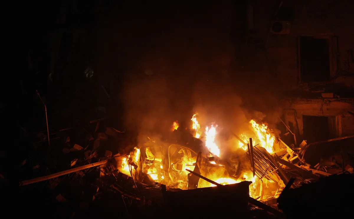 A car is engulfed in flames near a destroyed residential building on February 02, 2023 in Kramatorsk, Ukraine. Photo: Serhii Mykhalchuk / Global Images Ukraine / Getty Images