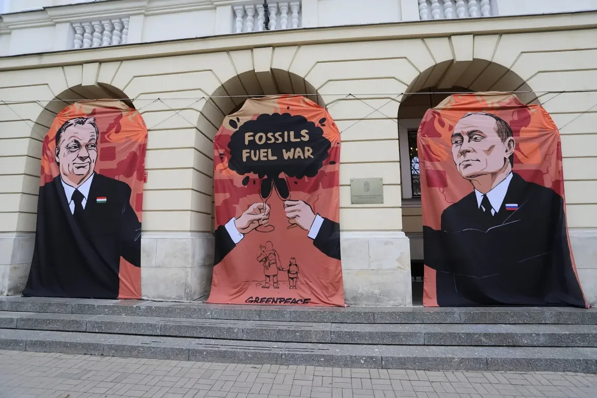 Баннер с изображением Виктора Орбана и Владимира Путина и лозунгом «Ископаемые — топливо войны» перед посольством Венгрии в Варшаве, 25 мая 2022 года. Фото: EPA-EFE / ZOFIA BICHNIEWICZ POLAND OUT