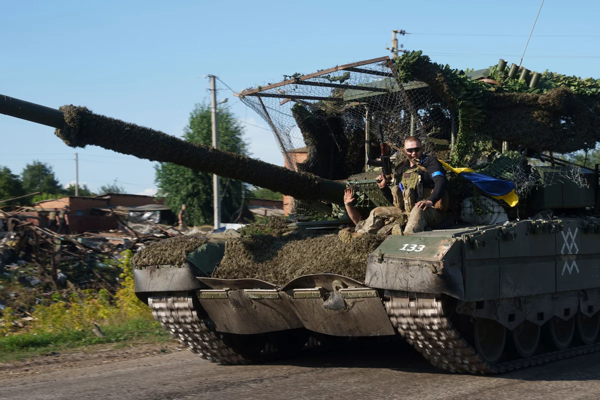 Украинский военнослужащий едет на трофейном танке после возвращения из России недалеко от российско-украинской границы в Сумской области, Украина, 15 августа 2024 года. Фото: Евгений Малолетка / AP Photo / Scanpix / LETA