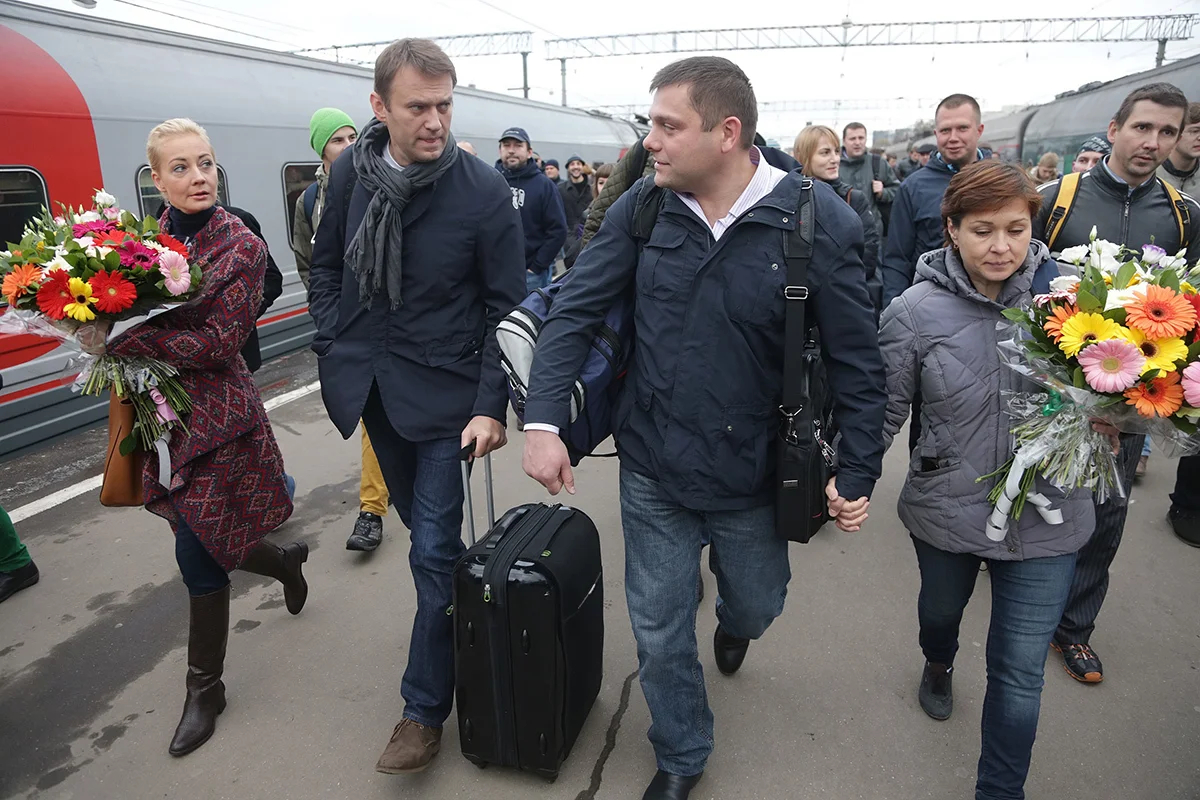 Алексей Навальный, его жена Юлия, Петр Офицеров и его жена Лидия прибывают из Кирова на Ярославский вокзал, Москва, 17 октября 2013 года. Фото: Максим Шипенков / EPA