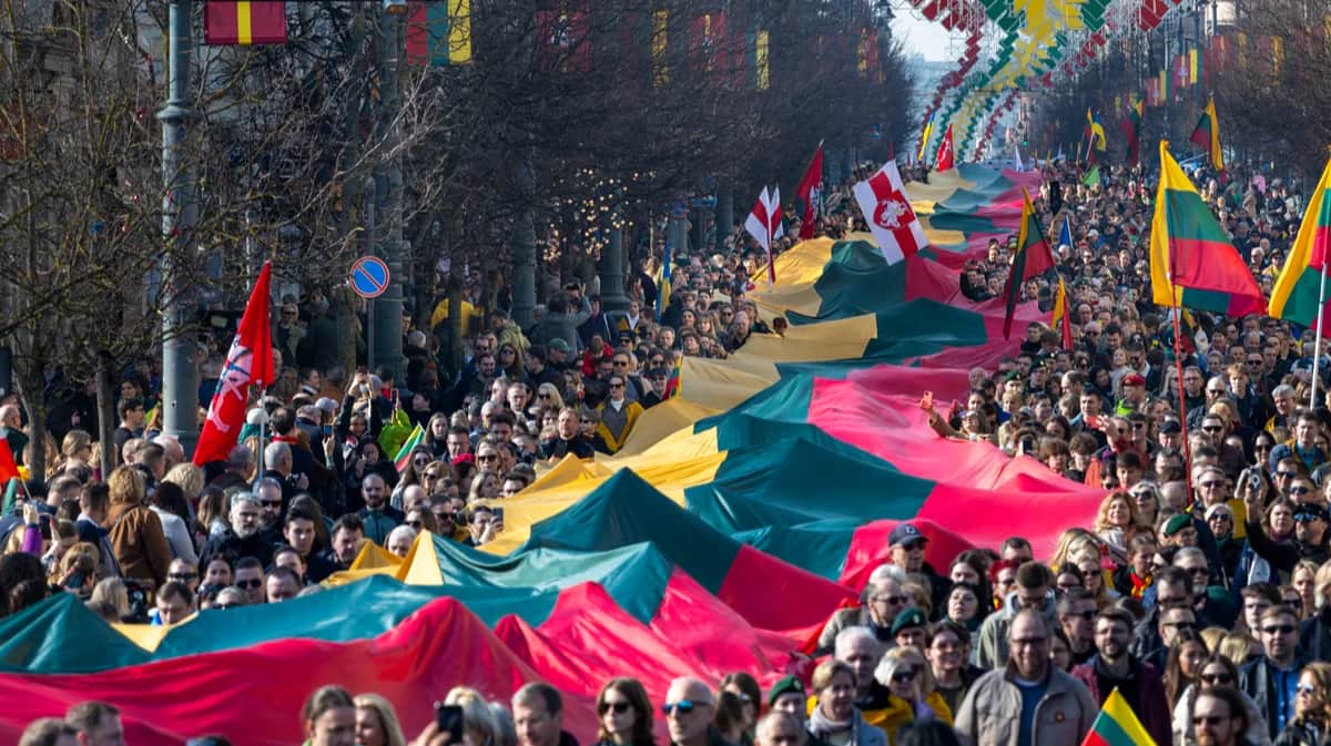 Люди несут гигантский флаг Литвы во время празднования 35-й годовщины независимости страны от Советского Союза, Вильнюс, 11 марта 2025 года. Фото: Mindaugas Kulbis / AP Photo / Scanpix / LETA