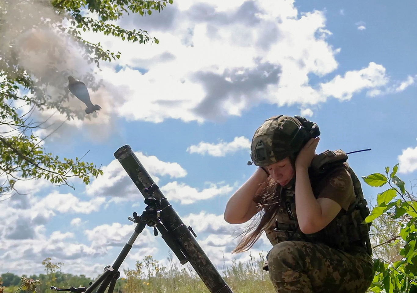 Украинская военнослужащая Варвара с позывным «Коса» стреляет из миномета во время тренировки в неустановленном месте в Сумской области. Северо-восток Украины. 12 августа 2025 года. Фото: Vitalii Nosach / EPA