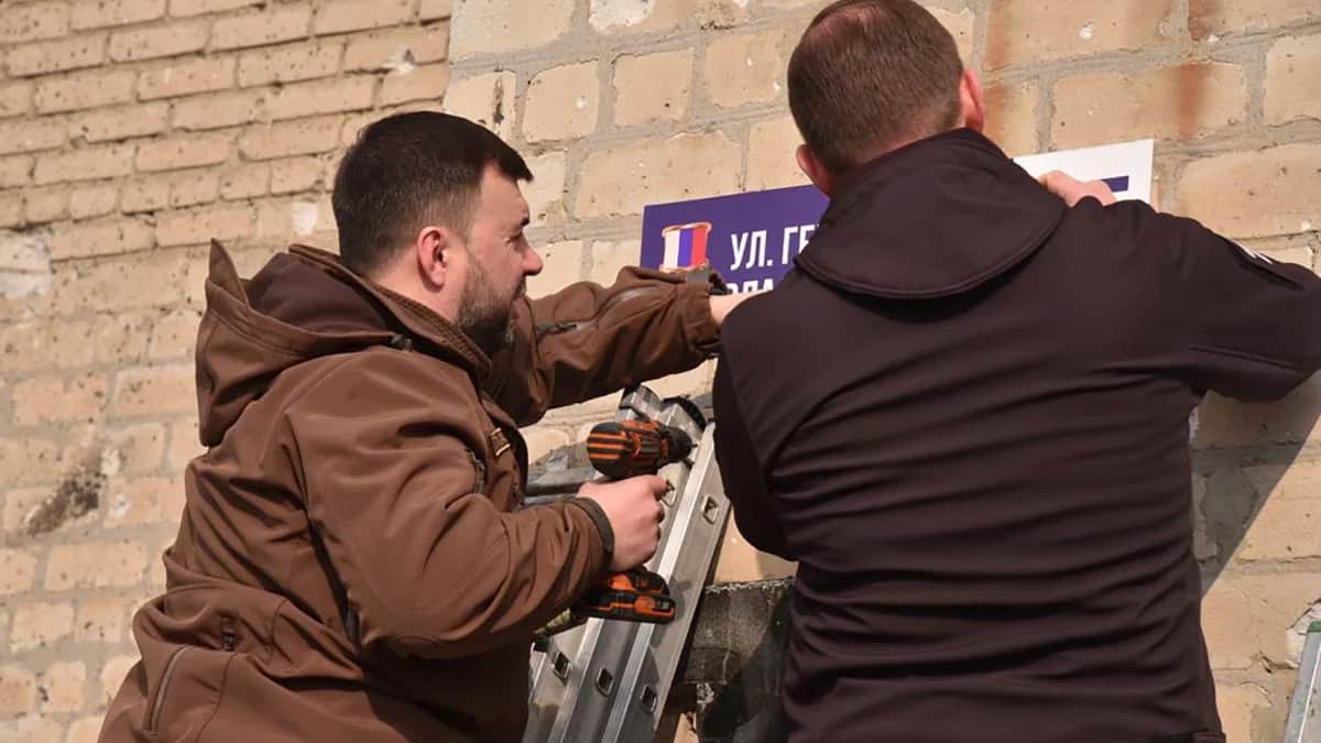 Андрей Турчак и Денис Пушилин прикрепляют таблицу с новым названием улицы в Волновахе. Фото: Единая Россия
