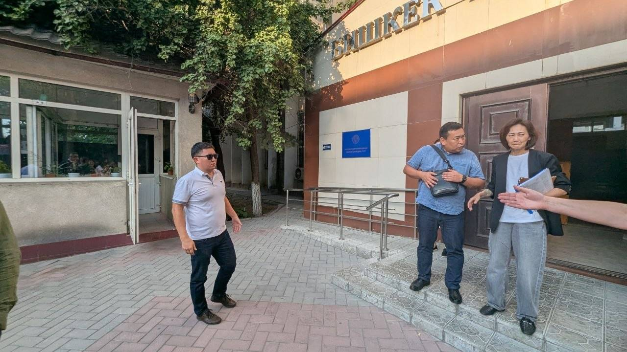 Адвокат Бородина Асель Аргымбаева и двое мужчин, представившихся сотрудниками миграционной службы, у здания суда. Фото предоставлено Ольгой