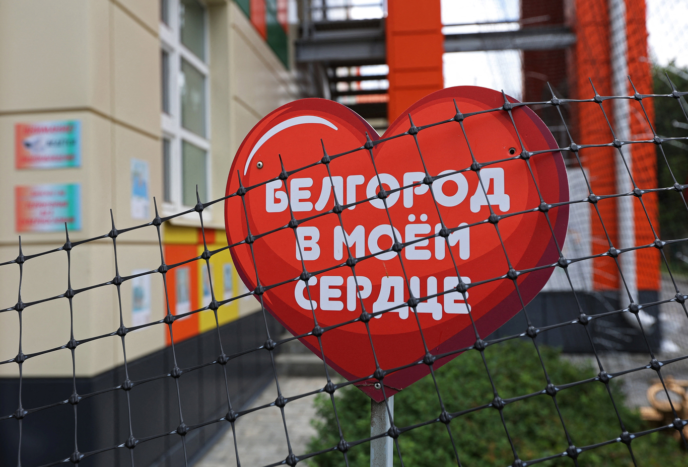 Инсталляция в форме сердца у здания детского сада, фасад которого защищен сеткой от атак беспилотников. Белгород. 26 августа 2025 года. Фото: Антон Вергун / Reuters / Scanpix / LETA