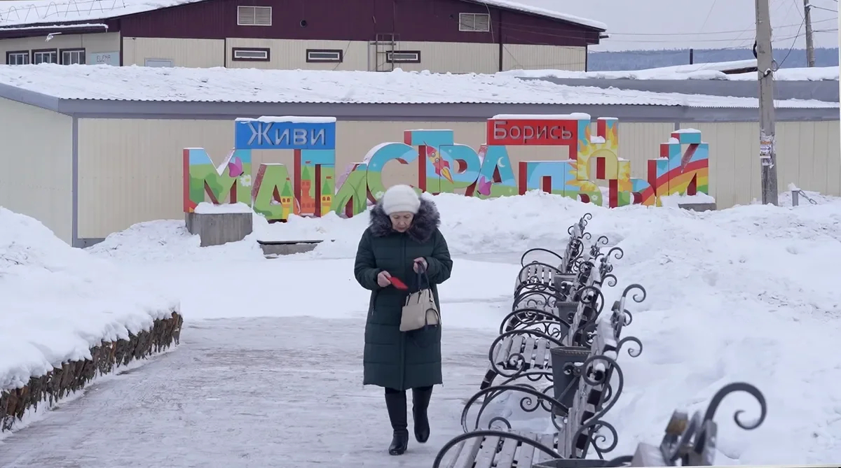‘Live. Fight’: a mural in the village of Magistralny, Irkutsk region. A shot from the film “Firewood for the mobilised”