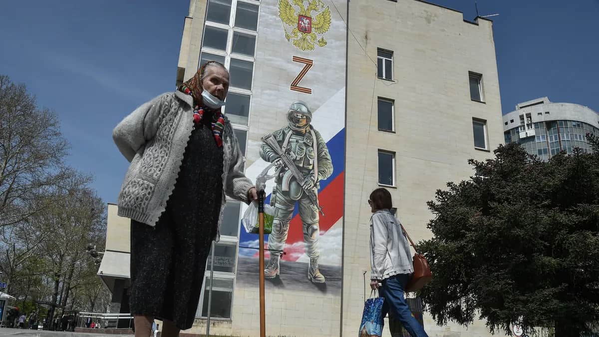 Пешеходы проходят мимо фрески с изображением российского солдата. Симферополь, Крым. Фото: EPA-EFE/STRINGER