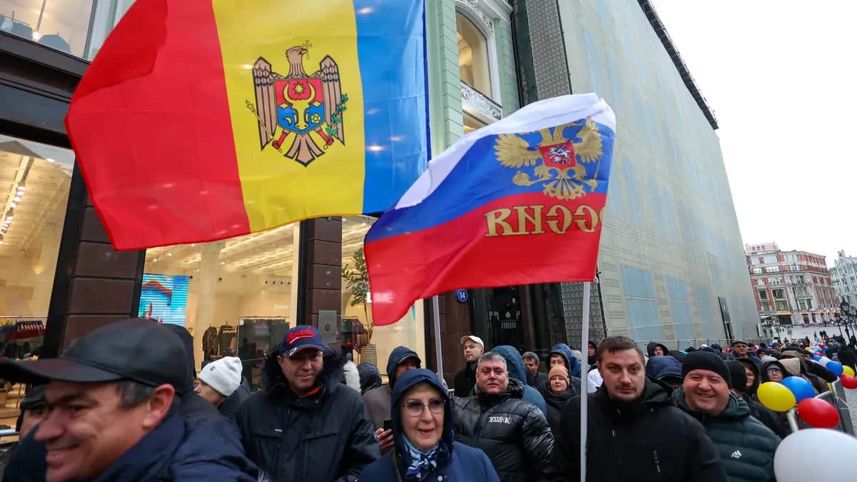 Moldovans living in Russia hold Moldovan and Russian flags as they line up to vote outside the Moldovan Embassy in Moscow, 3 November 2024. Photo: EPA/SERGEI ILNITSKY