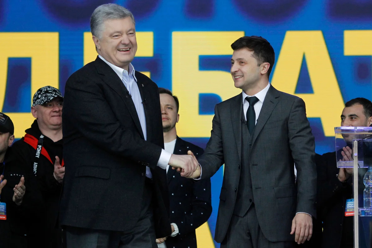 Кандидаты в президенты Петр Порошенко (слева) и Владимир Зеленский (справа) пожимают друг другу руки во время участия в дебатах в Киеве, Украина, 19 апреля 2019 года. Фото: Сергей Долженко / EPA-EFE