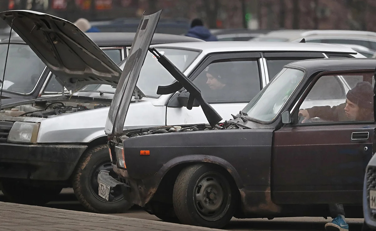 Игрушечный автомат Калашникова держит капот старых «Жигулей», Москва, Россия, 27 ноября 2021 года. Фото: Максим Шипенков / EPA