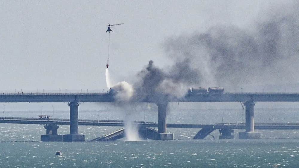 A firefighter helicopter pours water on fire on a collapsed part of the Kerch Strait bridge in Crimea, 08 October 2022. Photo: EPA-EFE/STRINGER