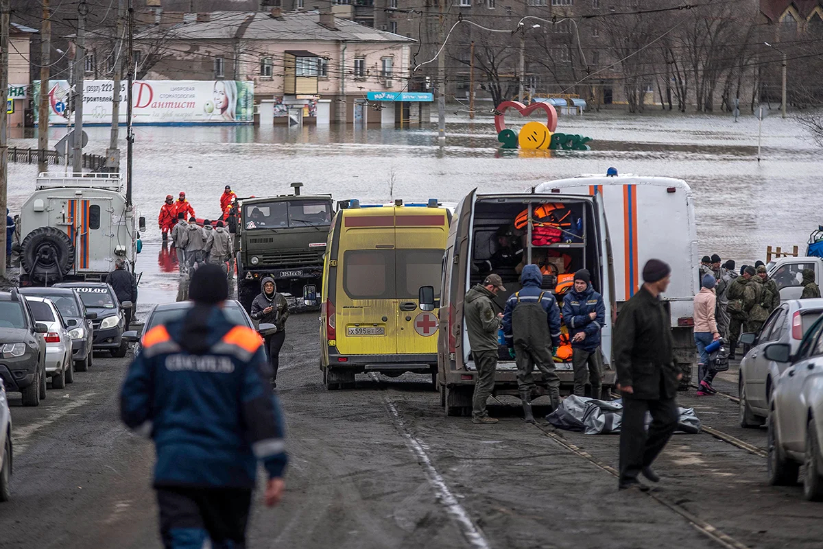 Сотрудники экстренных служб собираются возле своих автомобилей во время эвакуации на затопленной улице после прорыва части дамбы в Орске, 8 апреля 2024 года. Фото: AP / Scanpix / LETA