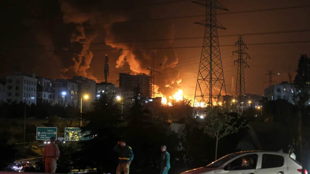 Пробка на шоссе на фоне пожара, охватившего нефтехранилище в районе Шахран на северо-западе Тегерана, Иран, 15 июня 2025 года. Фото: Atta Kenare / AFP / Scanpix / LETA