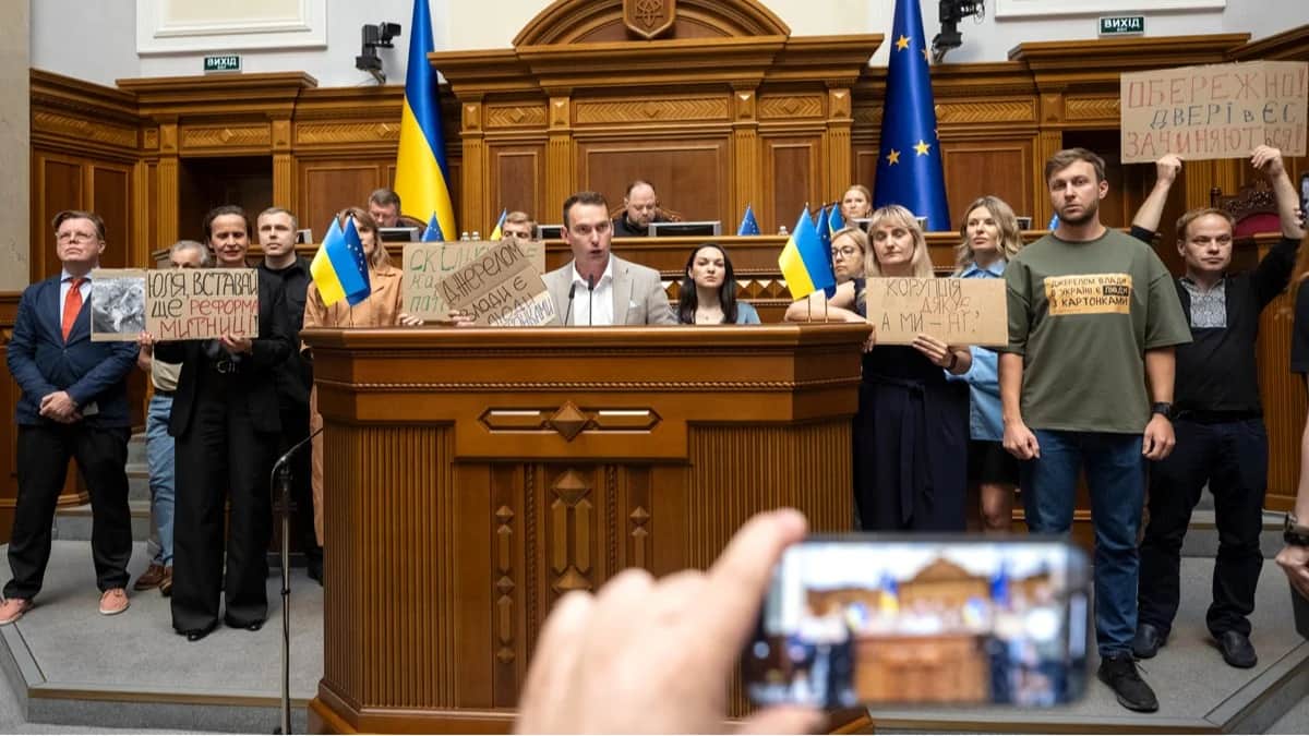 Украинские депутаты держат плакаты во время сессии парламента, посвященной восстановлению независимости антикоррупционных органов, Киев, Украина, 31 июля 2025 года. Фото: Andrii Nesterenko / EPA