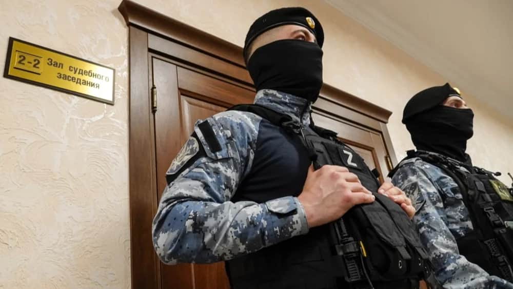 Russian police officers stand guard as a Russian military court delivers a verdict in the trial against 24 Ukrainian soldiers. Photo: EPA-EFE/STRINGER