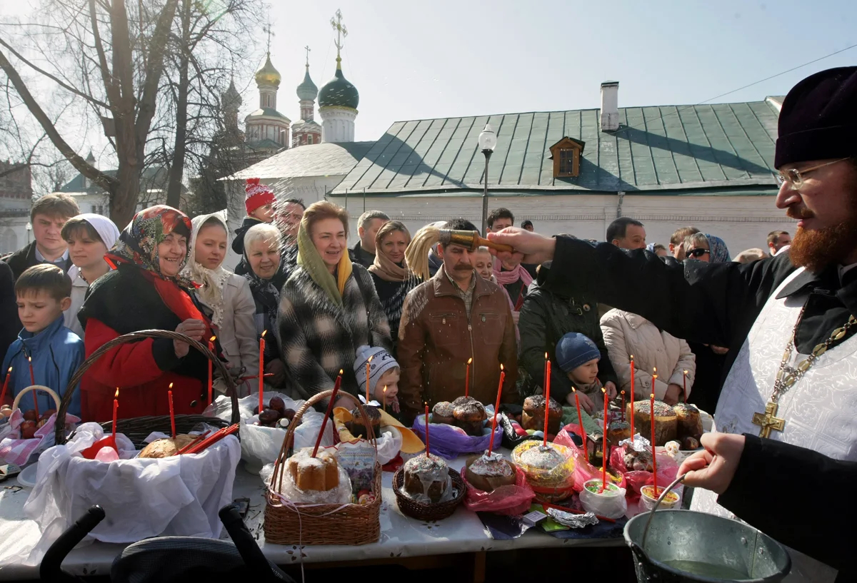 Священник русской православной церкви окропляет святой водой пасхальные куличи и яйца в Новодевичьем монастыре Москвы, 3 апреля 2010 года. Фото: Сергей Чириков / EPA