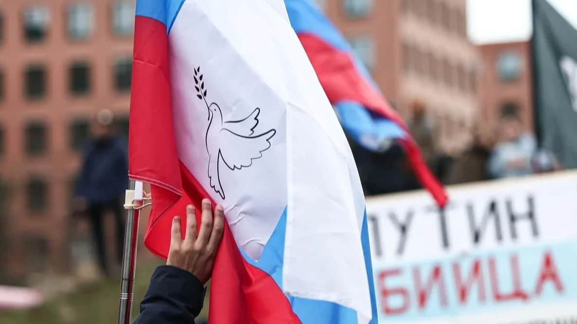 A protestor carries a Ru ssian flag featuring a dove of peace, Berlin, Germany , 1 March 2025. Photo: Hannes P. Albert / dpa / Scanpix / LETA